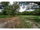 Overgrown lot with dirt path and mature trees at 7813 Valrie Ln, Riverview, FL 33569