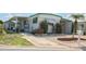 White single-wide manufactured home with green trim, carport, and landscaped yard at 107 E Saint Johns Way, Apollo Beach, FL 33572