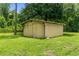 Yellow metal storage shed in grassy yard at 28541 Lindenhurst Dr, Wesley Chapel, FL 33544