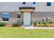 Light blue front door with landscaping and pathway at 31807 Blue Passing Loop, Wesley Chapel, FL 33545