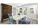 Bright dining area with white table, blue chairs, and large wooden cabinet at 401 Appian Ne Way, St Petersburg, FL 33704