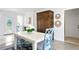 Bright dining area with white table and blue chairs near a wooden cabinet at 401 Appian Ne Way, St Petersburg, FL 33704