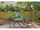 Relaxing patio area with small table and chairs, surrounded by lush greenery at 401 Appian Ne Way, St Petersburg, FL 33704