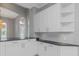 Modern kitchen with white cabinets, dark countertops, and a large island at 6218 Bridleford Dr, Wesley Chapel, FL 33545