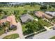 Stunning aerial view of a luxury home with a tile roof, pool, manicured lawn, and golf course in the background at 33724 Americana Ave, Dade City, FL 33525