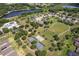 Beautiful aerial view of a community featuring a park with tennis courts, a basketball court, and a verdant green space at 33724 Americana Ave, Dade City, FL 33525