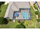 Aerial view of the screened-in pool area with beautiful landscaping at 33724 Americana Ave, Dade City, FL 33525