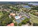 Aerial view of the community clubhouse, swimming pool, tennis courts, parking, and a scenic lake at 33724 Americana Ave, Dade City, FL 33525