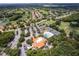 Aerial view showcasing the community clubhouse, swimming pool, tennis courts, and a lush green golf course at 33724 Americana Ave, Dade City, FL 33525