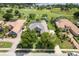 Aerial view of home with landscaped yard, golf course, and lake views at 33724 Americana Ave, Dade City, FL 33525