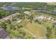Lovely community aerial view featuring beautiful ponds, lush trees, manicured green spaces, and neatly arranged homes at 33724 Americana Ave, Dade City, FL 33525