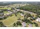 Scenic aerial view of a lovely community park featuring walking paths, tennis courts, and verdant lawns at 33724 Americana Ave, Dade City, FL 33525
