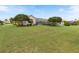 Expansive backyard with lush lawn, mature trees, and a screened-in pool area at 33724 Americana Ave, Dade City, FL 33525