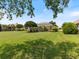 Expansive backyard featuring lush lawn, mature trees, and a screened lanai at 33724 Americana Ave, Dade City, FL 33525
