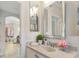 Bathroom showcasing double mirrors, a decorative plant, and an adjacent living area with natural light at 33724 Americana Ave, Dade City, FL 33525