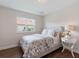 Well-lit bedroom featuring a comfortable bed, hardwood floors, and a view from the window at 33724 Americana Ave, Dade City, FL 33525