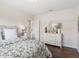 Bright bedroom featuring a floral patterned bedspread and a white dresser with a round mirror at 33724 Americana Ave, Dade City, FL 33525