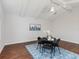 Bright dining room with vaulted ceilings, hardwood floors, and a modern city skyline artwork at 33724 Americana Ave, Dade City, FL 33525