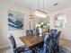 Elegant dining room boasting a modern chandelier and views through to the kitchen and outdoor scenery at 33724 Americana Ave, Dade City, FL 33525