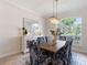Chic dining room with a wooden table, patterned chairs, mirrored wall decor, and a modern chandelier at 33724 Americana Ave, Dade City, FL 33525