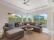 Comfortable living room with a large sectional sofa, plush rug, and views of the outdoor patio and garden at 33724 Americana Ave, Dade City, FL 33525