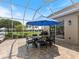 Covered patio with dining table and chairs overlooking the lush backyard and golf course at 33724 Americana Ave, Dade City, FL 33525