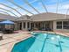 Inviting pool area with a screened enclosure, patio seating, and clear blue water for relaxation at 33724 Americana Ave, Dade City, FL 33525