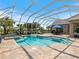 Screened-in pool area with a water feature, ample seating, and lush landscaping at 33724 Americana Ave, Dade City, FL 33525
