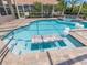 Beautiful swimming pool with a built-in table and chairs, spa, and pristine clear water at 33724 Americana Ave, Dade City, FL 33525