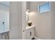 Half bathroom with white vanity, modern fixtures, and a decorative mirror at 5243 Wishing Arch Dr, Apollo Beach, FL 33572