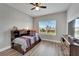 Cozy bedroom with hardwood floors features a daybed, mounted TV, ceiling fan, and serene water views at 5243 Wishing Arch Dr, Apollo Beach, FL 33572