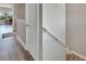 Bright upstairs hallway featuring wood floors and railing leading to the stairs at 5243 Wishing Arch Dr, Apollo Beach, FL 33572