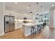 Modern kitchen with white cabinets, stainless steel appliances, large island, and barstool seating at 5243 Wishing Arch Dr, Apollo Beach, FL 33572