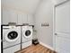 Functional laundry room with gray cabinets, wood floors, and modern appliances at 5243 Wishing Arch Dr, Apollo Beach, FL 33572