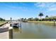 Exterior waterfront features a private boat lift and picturesque views of the canal and nearby homes at 5243 Wishing Arch Dr, Apollo Beach, FL 33572