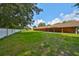 Expansive backyard featuring a large, well-maintained grassy area, and a long covered patio providing ample outdoor space at 12922 672 Hwy, Riverview, FL 33579