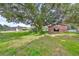 Lush green backyard with a large tree and outbuildings visible at 12922 672 Hwy, Riverview, FL 33579