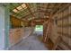 Interior view of barn stalls with a ladder and a metal roof overhead at 12922 672 Hwy, Riverview, FL 33579