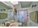 A bright bathroom featuring colorful hummingbird shower curtain, vanity and a sink, with blue walls at 12922 672 Hwy, Riverview, FL 33579
