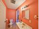 View of bathroom with pink walls, toilet, sink, and mirror at 12922 672 Hwy, Riverview, FL 33579