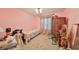 A cozy bedroom featuring pink walls, neutral carpet, and a twin bed, with a chest of drawers at 12922 672 Hwy, Riverview, FL 33579