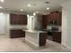 Spacious kitchen features dark cabinets, stainless steel appliances, and a center island at 11522 Cambium Crown Dr, Riverview, FL 33569