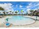 Community pool area with palm trees, lounge chairs, and splash pad under a bright sky at 11522 Cambium Crown Dr, Riverview, FL 33569