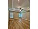 Spacious primary bedroom with tray ceilings, fan, and wood-look flooring at 13530 Oldenburg Dr, Hudson, FL 34667
