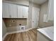 Functional laundry room with white cabinets, and wood-look flooring at 13530 Oldenburg Dr, Hudson, FL 34667