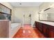 Large bathroom boasts tile floors, double vanity, soaking tub, and doorway to walk-in closet at 614 Vintage Way, Brandon, FL 33511