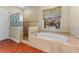 Bathroom with soaking tub, glass shower, neutral wall, and tile floors at 614 Vintage Way, Brandon, FL 33511