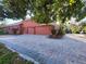 Exterior of home featuring brick paver driveway, colorful shrubs, and a three car garage at 614 Vintage Way, Brandon, FL 33511