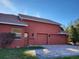 Exterior view of a red home with a tile roof and a three-car garage at 614 Vintage Way, Brandon, FL 33511