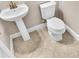 Half bath with pedestal sink, toilet, and tiled floor at 11522 Cambium Crown Dr, Riverview, FL 33569